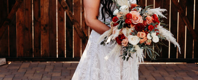 Bride with bouquet in front of barn doors
