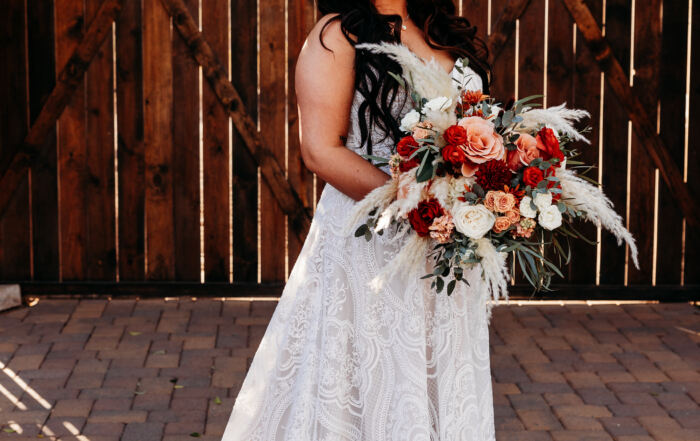 Bride with bouquet in front of barn doors