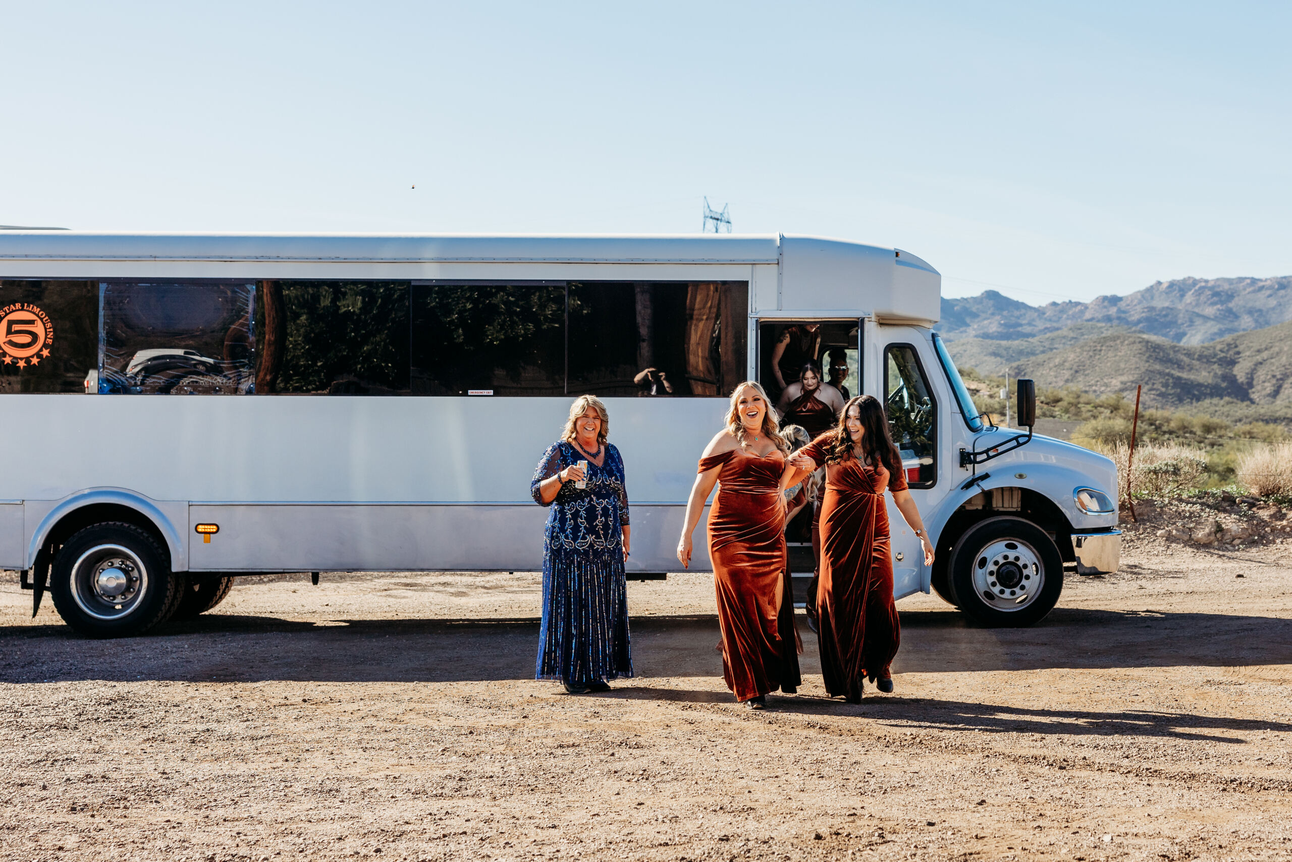 Bridesmaids arriving by party bus at mountain-view wedding venue in Arizona